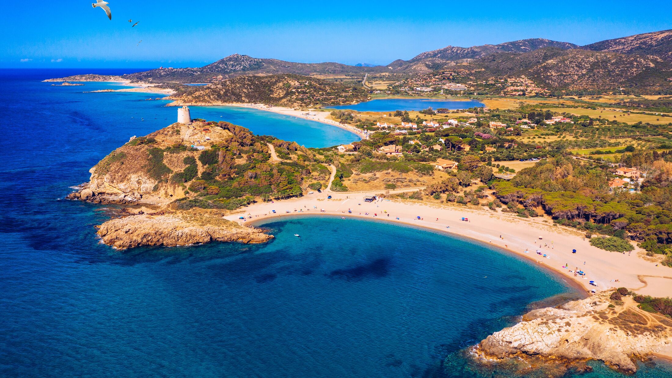 Torre di Chia view from flying drone. Acropoli di Bithia with Torre di Chia tower on background. Aerial view of Sardinia island, Italy, Europe. Panorama Of Chia Coast, Sardinia, Italy.