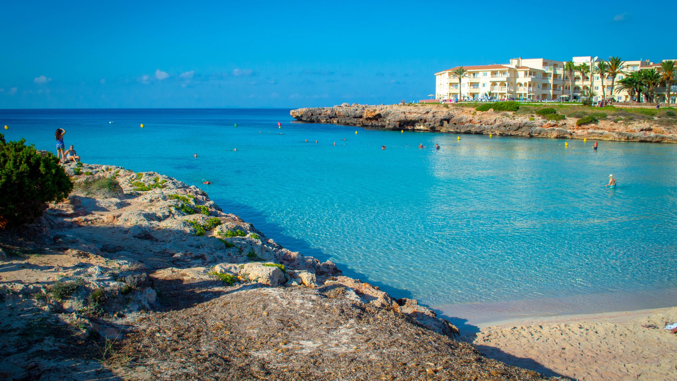 Holidays cala n'bosch beach minorca . Cami de cavalls. Beautiful minorca beach with small hotel in the background. white sand and turquoise water