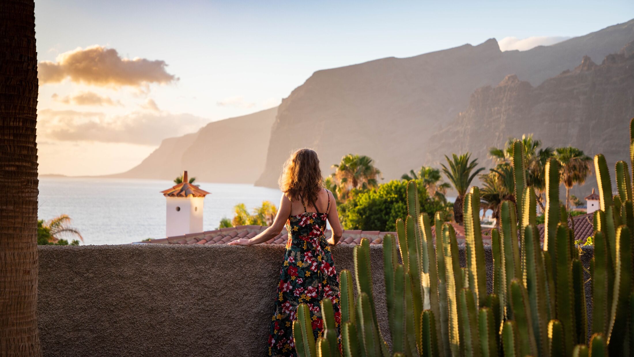 Woman looking out at Los Gigantes, Tenerife at Sunset