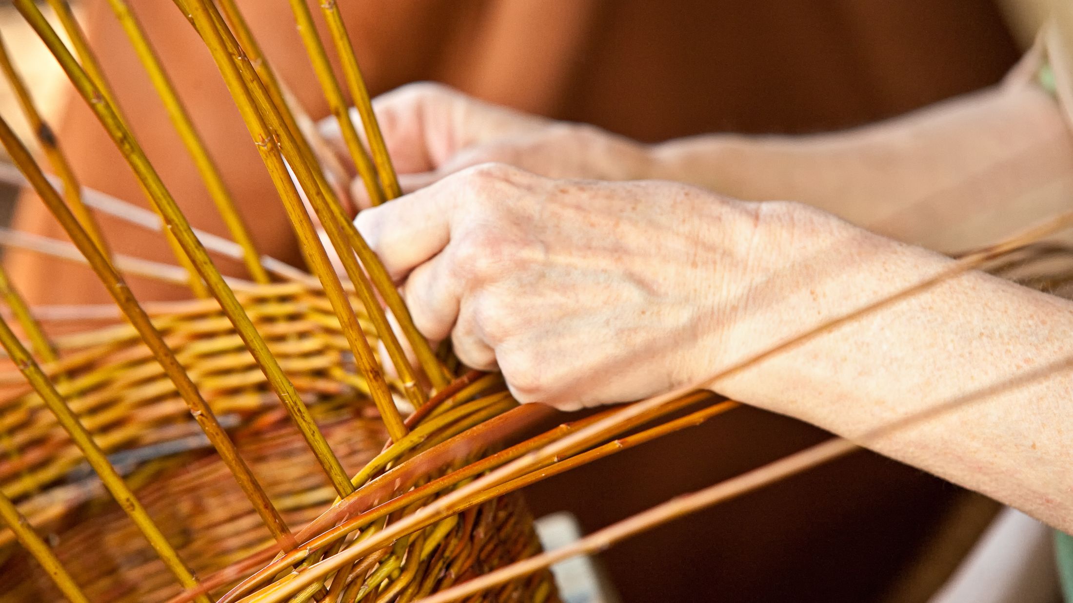 "Hands of a women, lacing a basket."