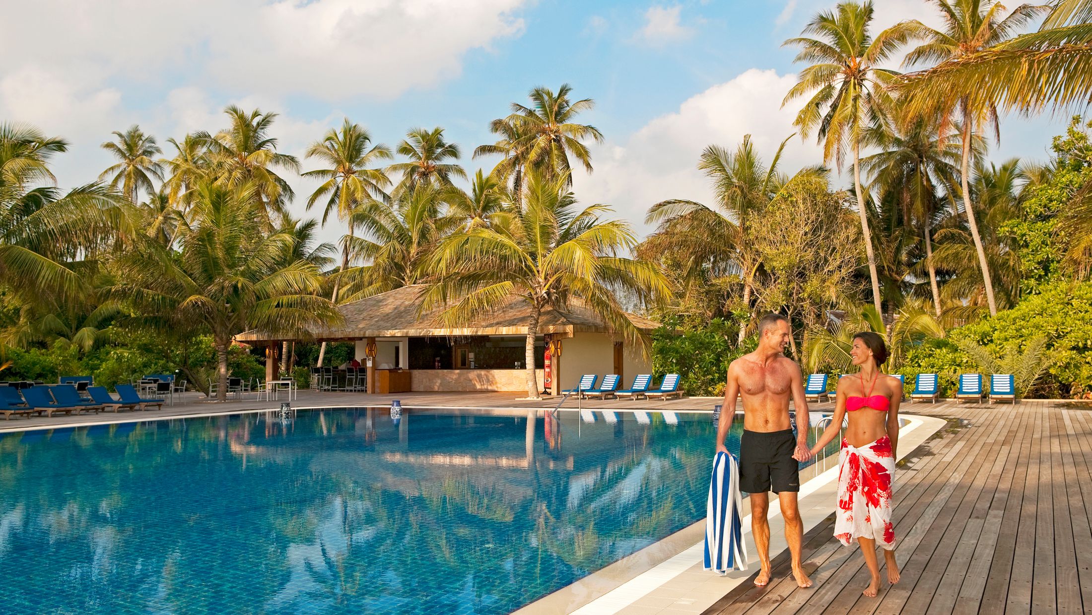 a person in a pool of water in front of a palm tree