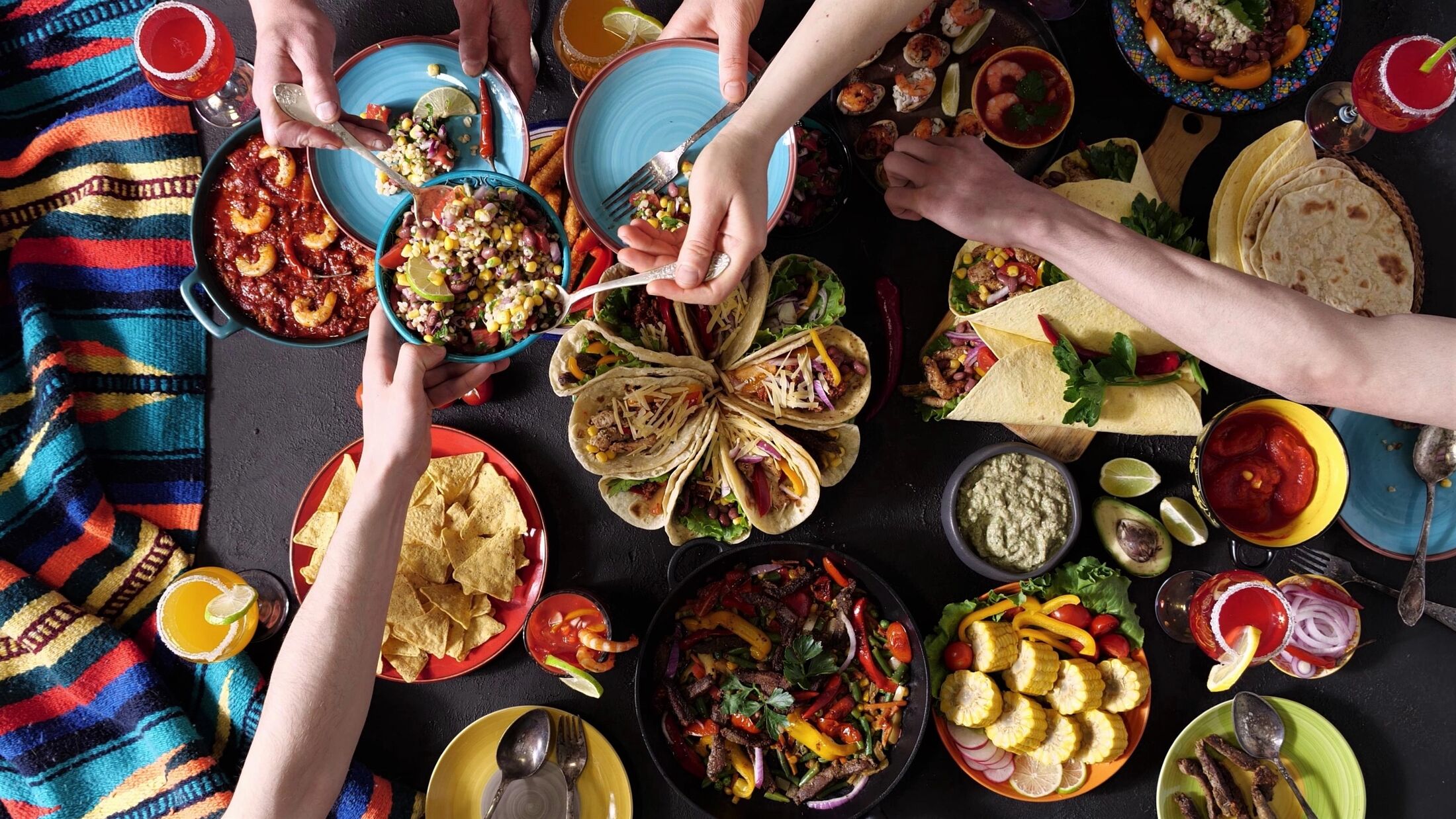 An authentic Mexican family celebrates Cinco de mayo together at a festive table. Mexican food.