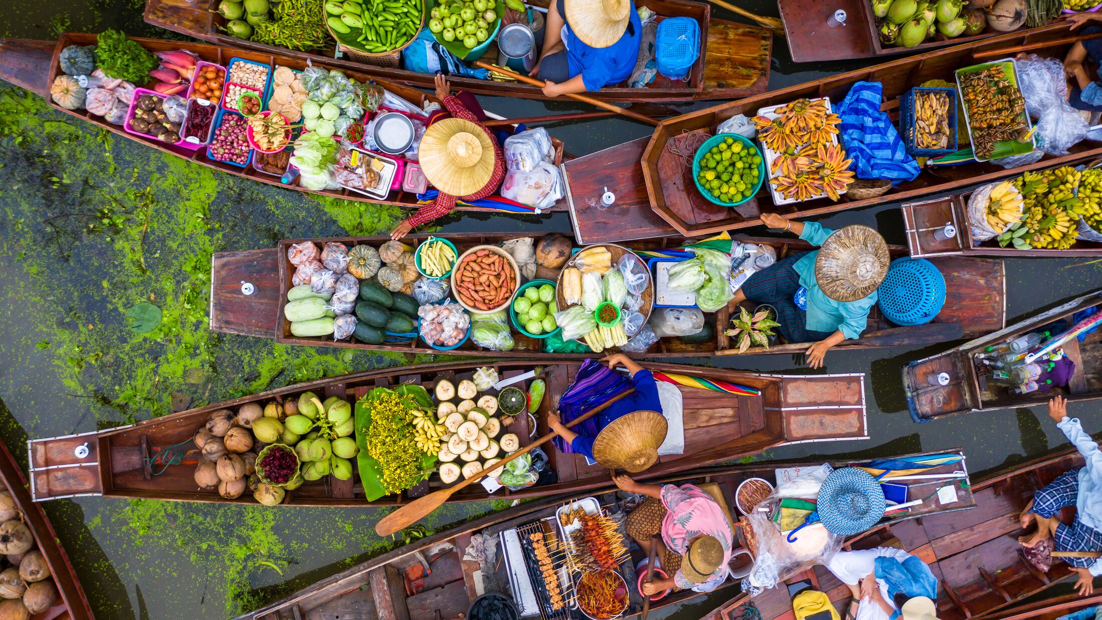 Aerial view famous floating market in Thailand, Damnoen Saduak floating market, Farmer go to sell organic products, fruits, vegetables and Thai cuisine, Tourists visiting by boat, Ratchaburi, Thailand