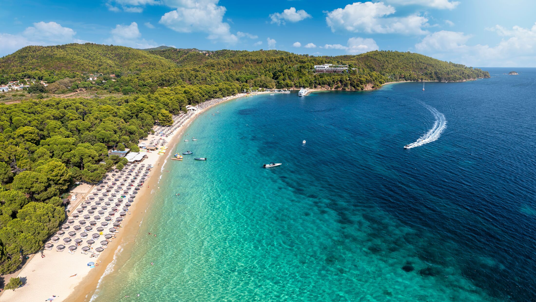 Beautiful Koukounaries beach on the island of Skiathos, Sporades, Greece, with emerald shining sea and lush vegetation on the surrounding hills