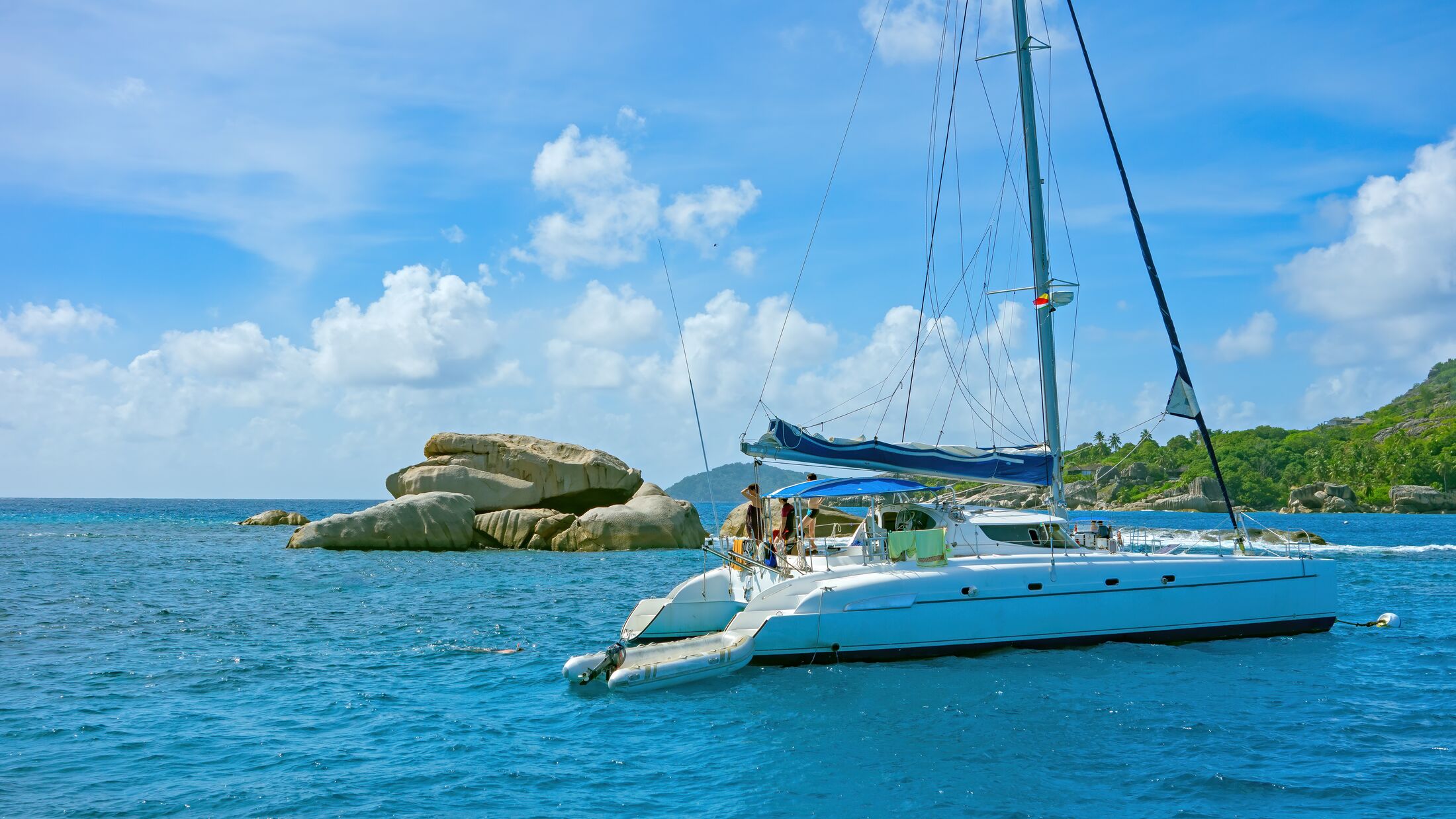 catamaran in a bay in the Seychelles, little Island with palm trees with granite rocks in the ocean