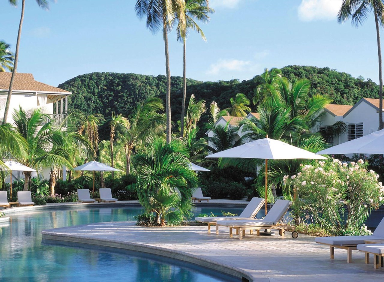 a pool next to a palm tree in front of a building