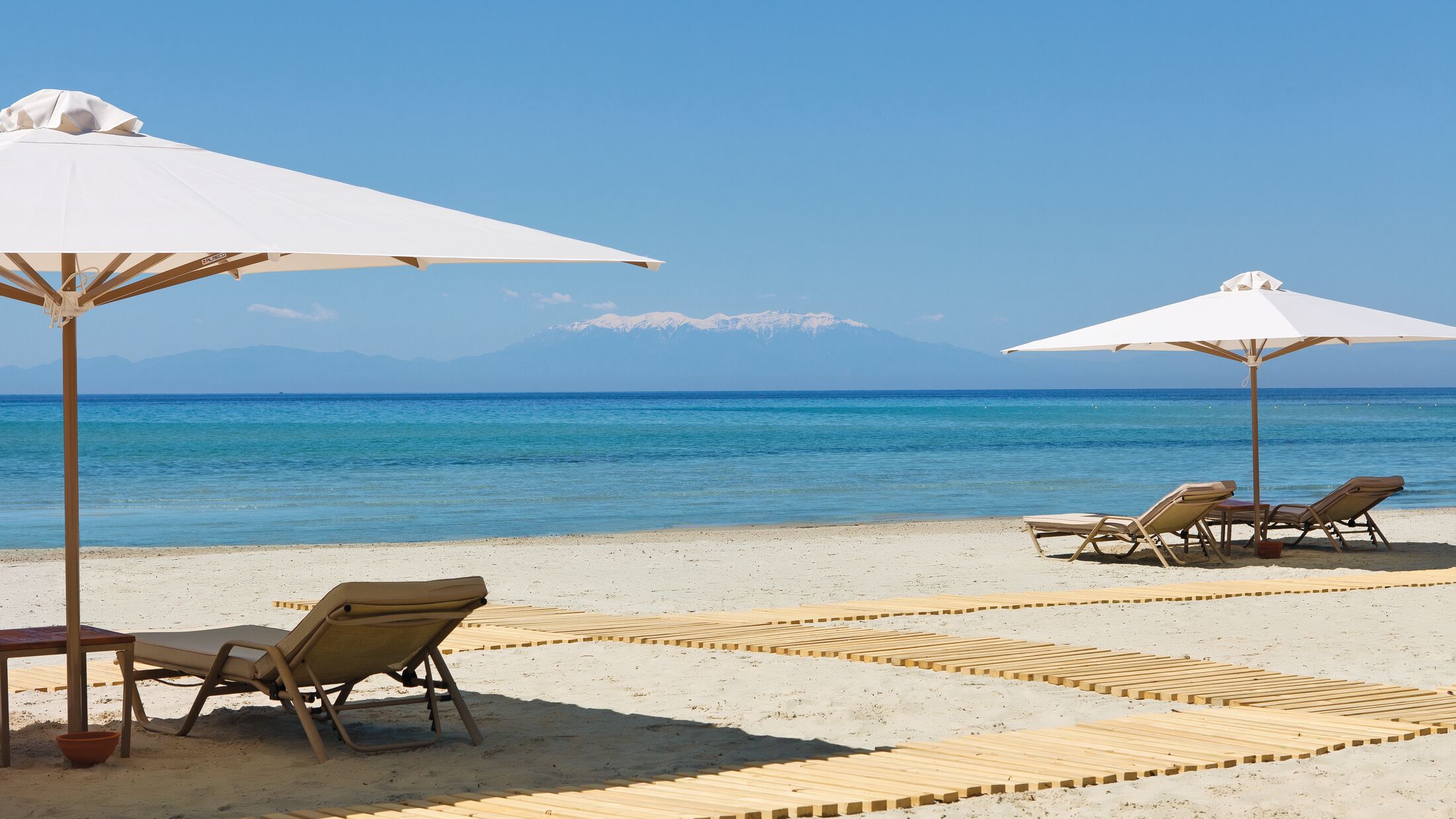 a couple of lawn chairs sitting on top of a beach