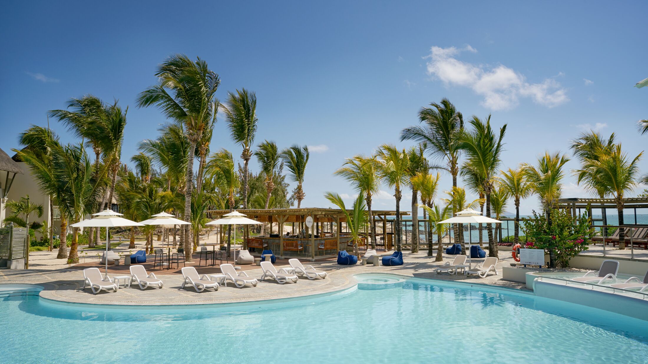 a group of palm trees next to a swimming pool