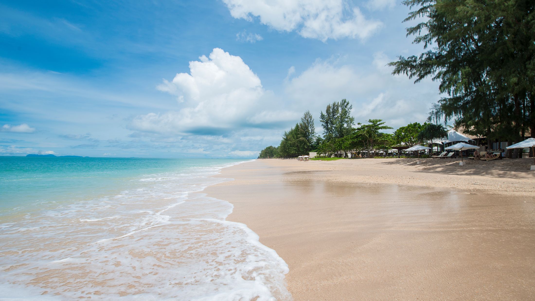 a sandy beach next to a body of water